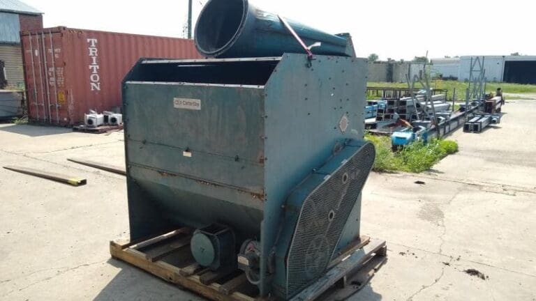 A large green machine sitting on top of a wooden crate.