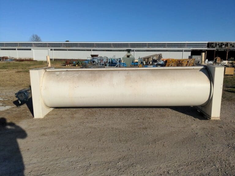 A large white pipe sitting in the middle of a road.