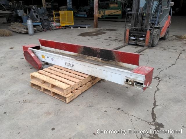 A red and white machine is sitting on some pallets