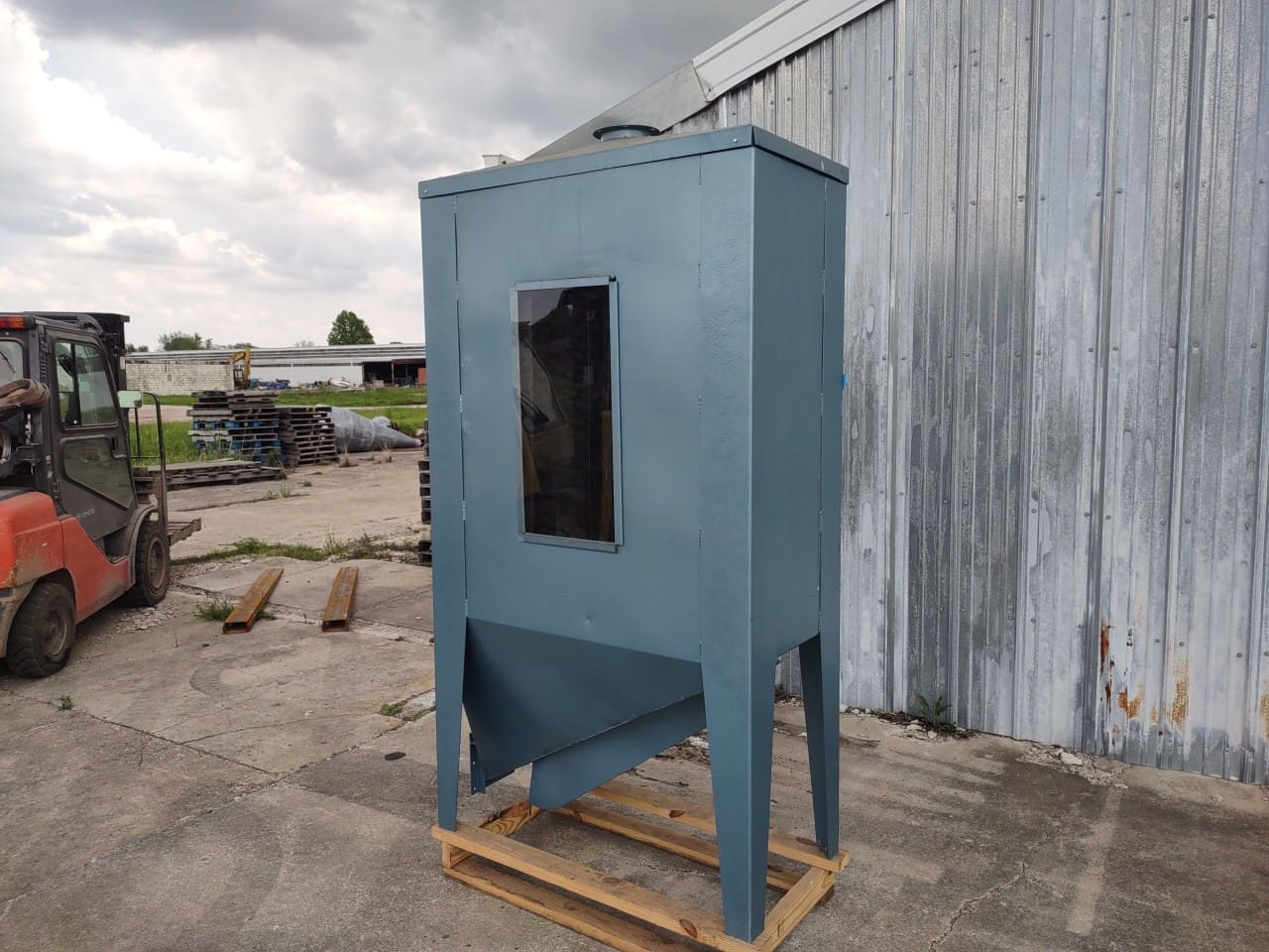 A blue cabinet sitting on top of a wooden pallet.