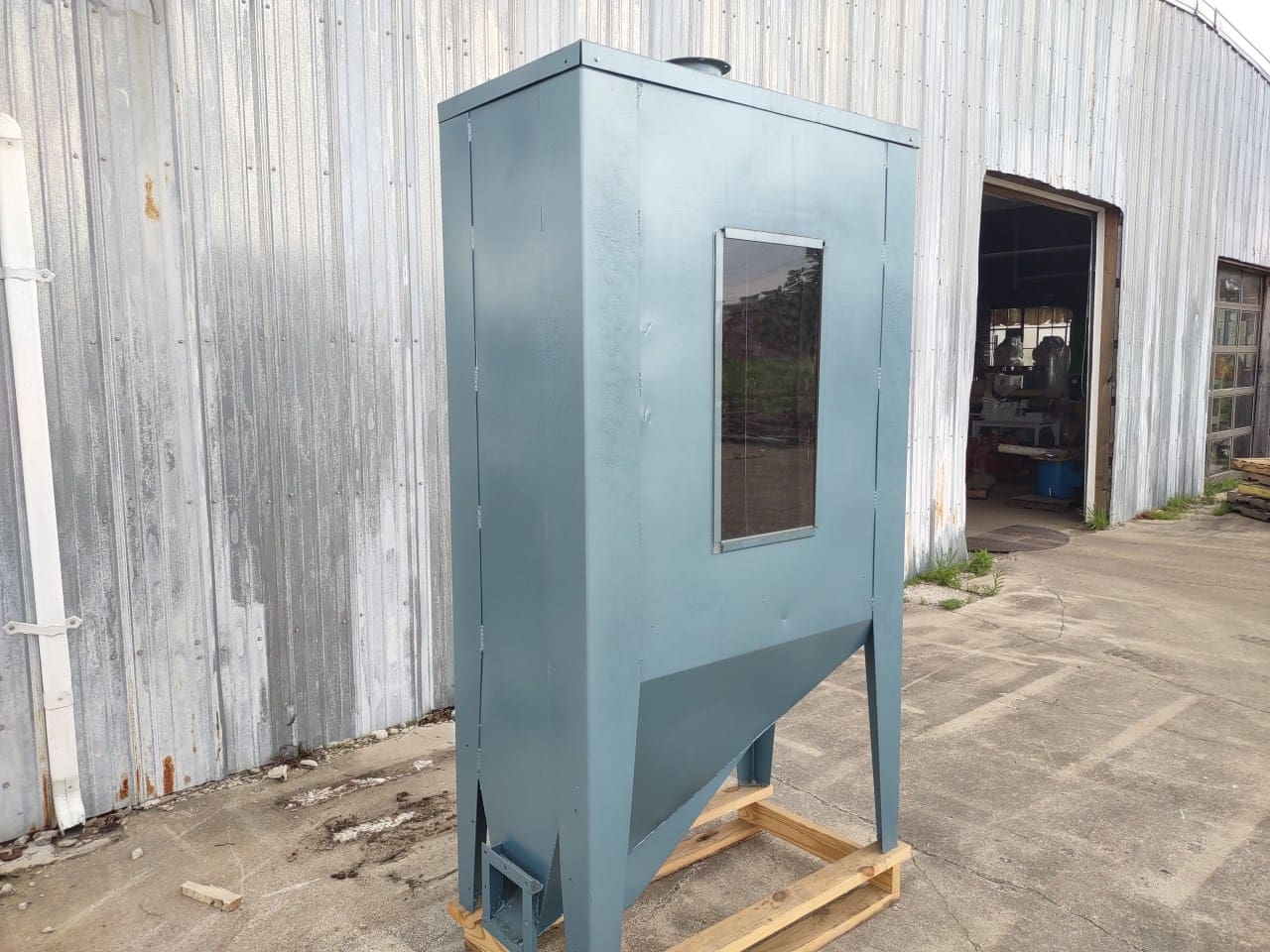 A blue metal cabinet sitting on top of a wooden pallet.