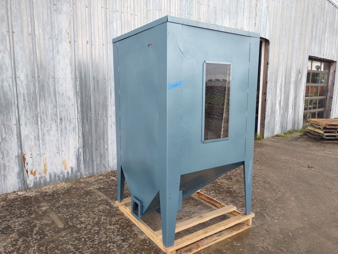 A blue metal box sitting on top of a wooden pallet.