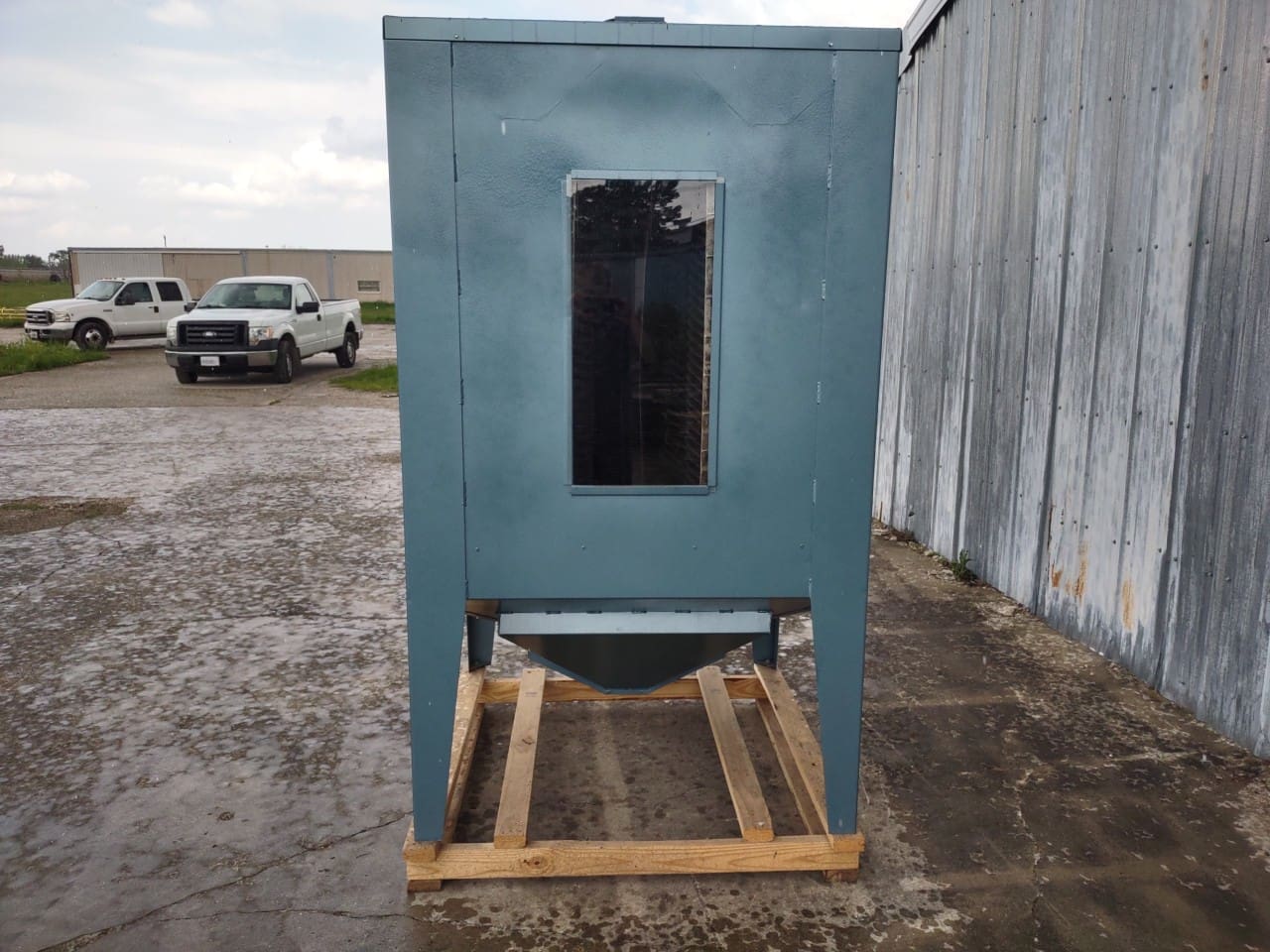 A blue metal box sitting on top of a wooden crate.