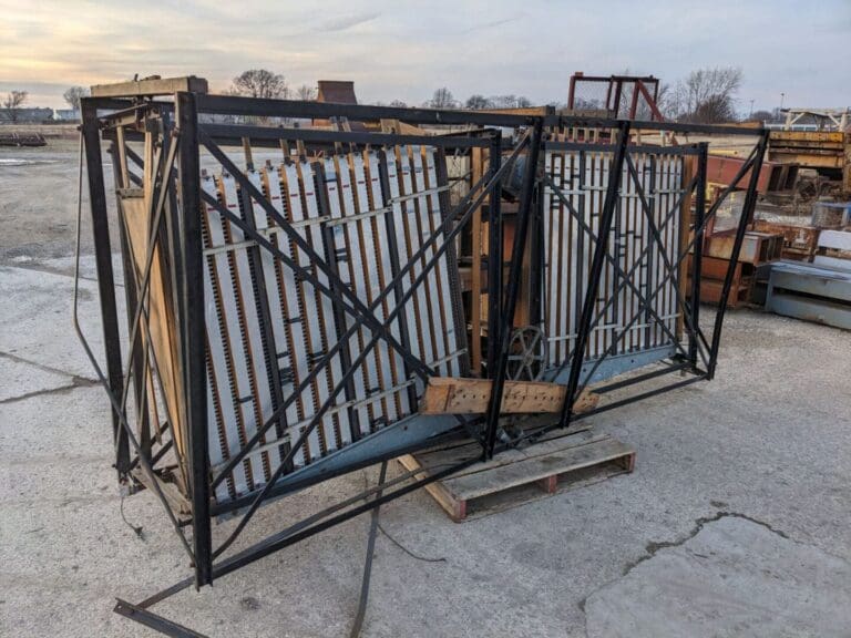 A large metal gate sitting on top of concrete.