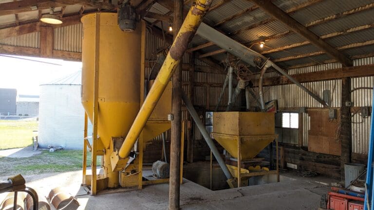 A large yellow machine in an old barn.
