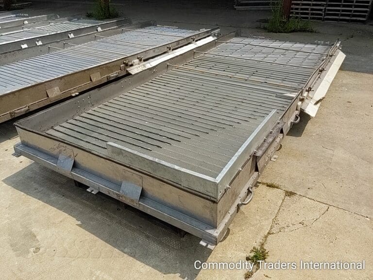 A couple of metal trays sitting on top of concrete.