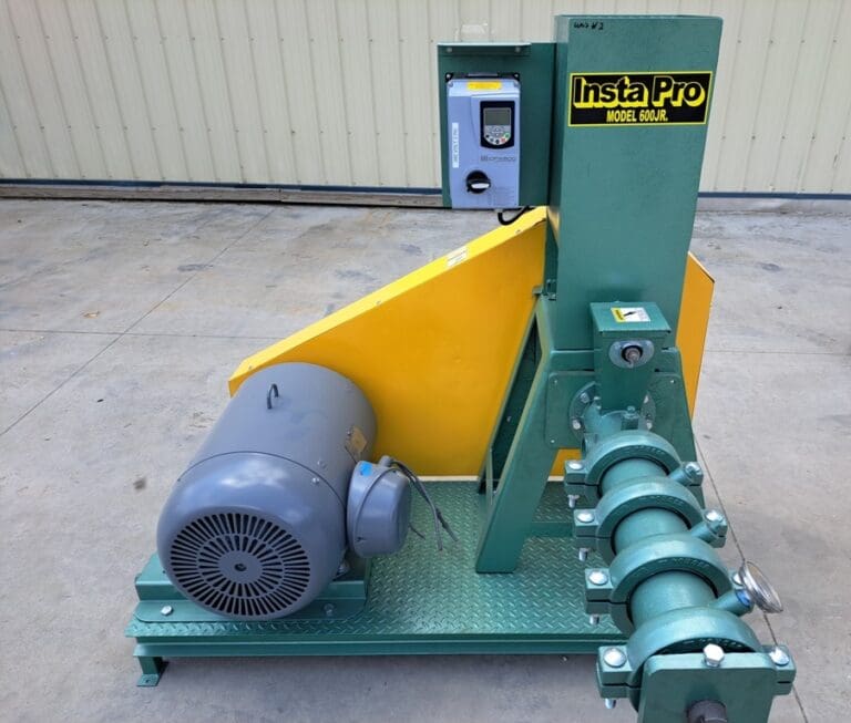 A green and yellow machine is sitting on the ground.
