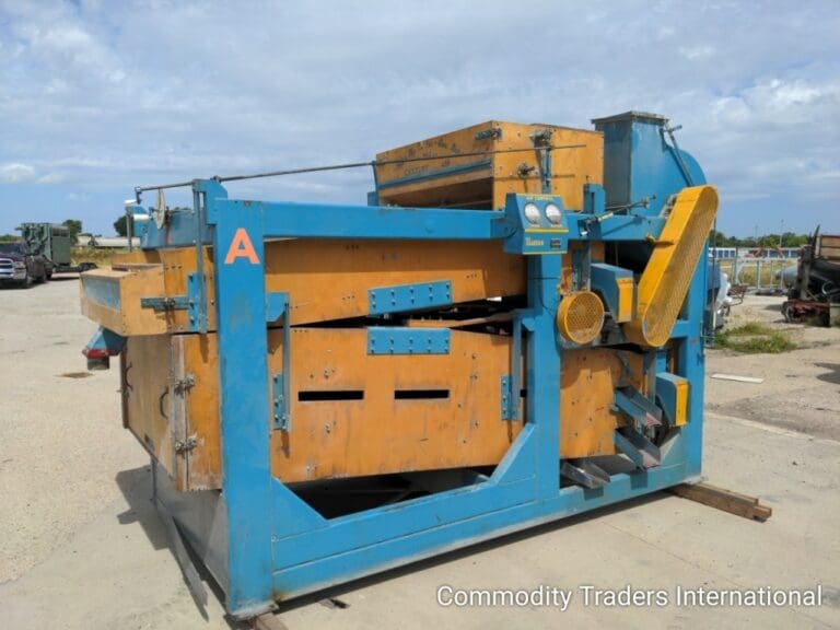 A blue and yellow machine is sitting in the dirt.