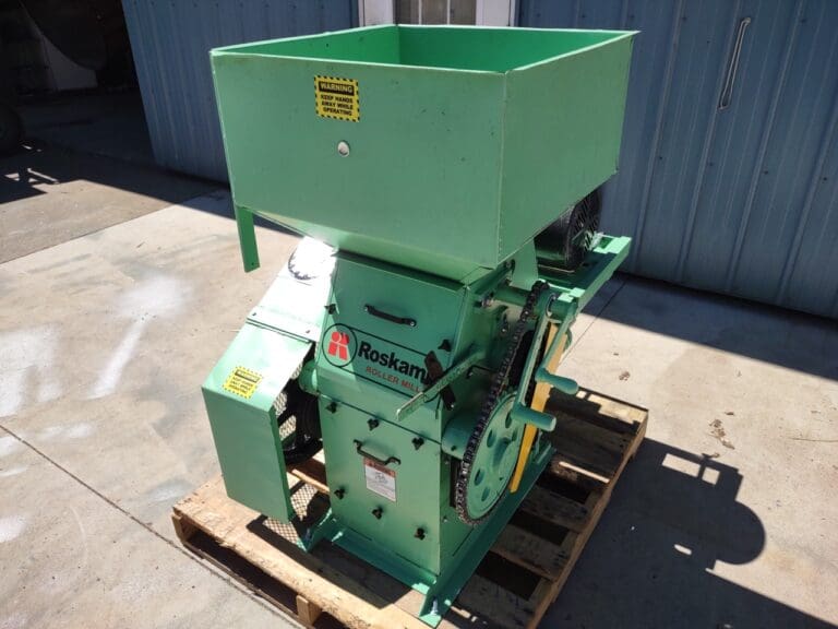 A green machine is sitting on the ground