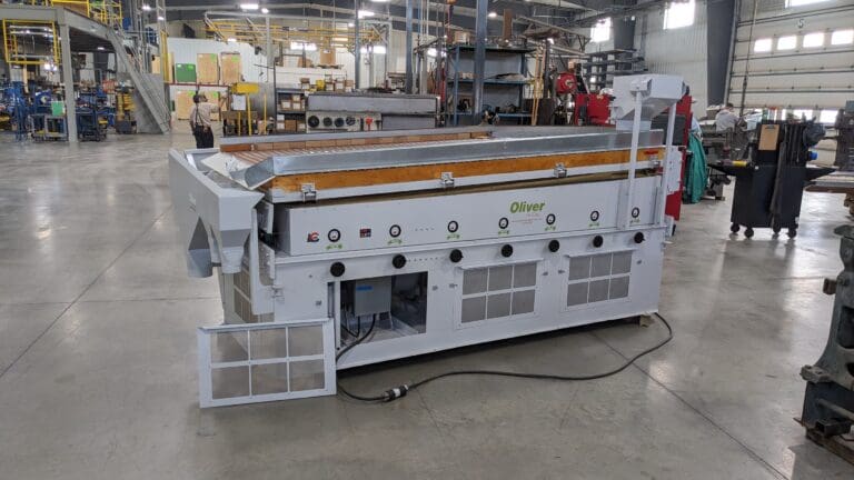 A large machine in a factory room with many other machines.