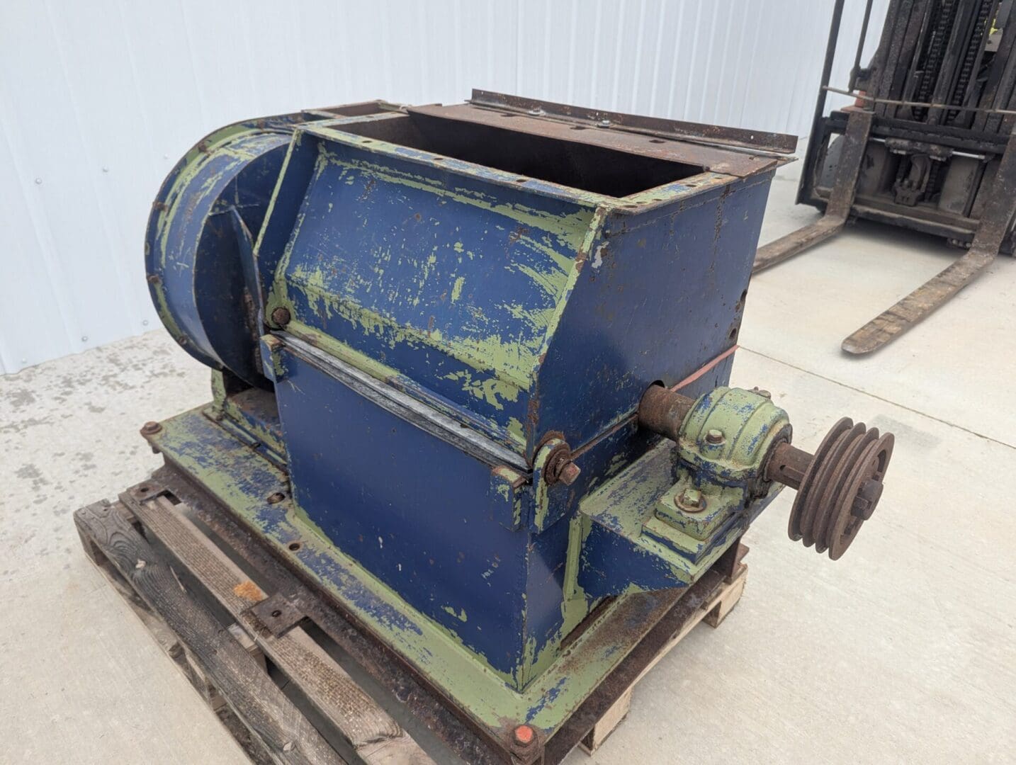 1000002061 A blue and green machine sitting on top of concrete.