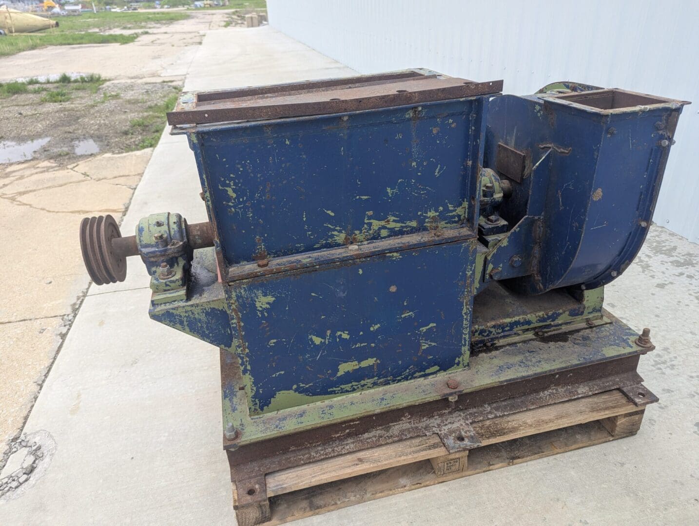 A blue machine sitting on top of a wooden board.