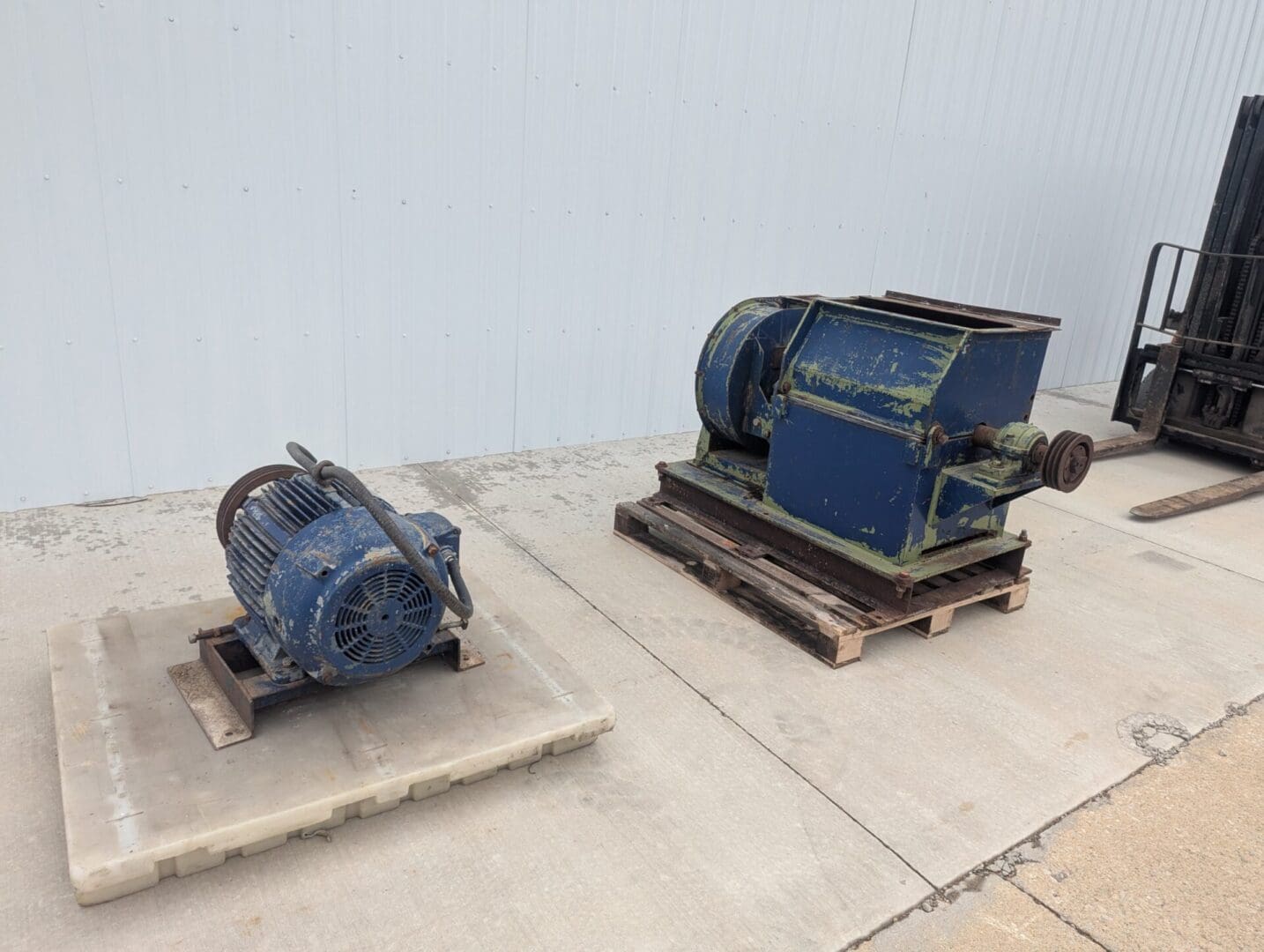 A blue motor and a blue engine on concrete.