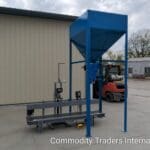A blue machine with a metal cart in front of it.
