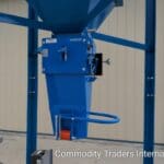 A blue machine is hanging from the side of a building.