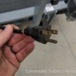 A person holding an electrical plug in their hand.