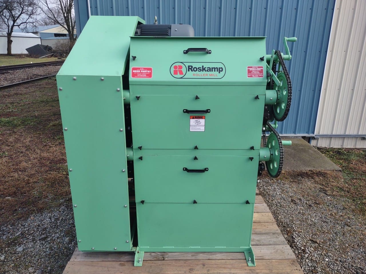 A green machine sitting on top of a wooden platform.
