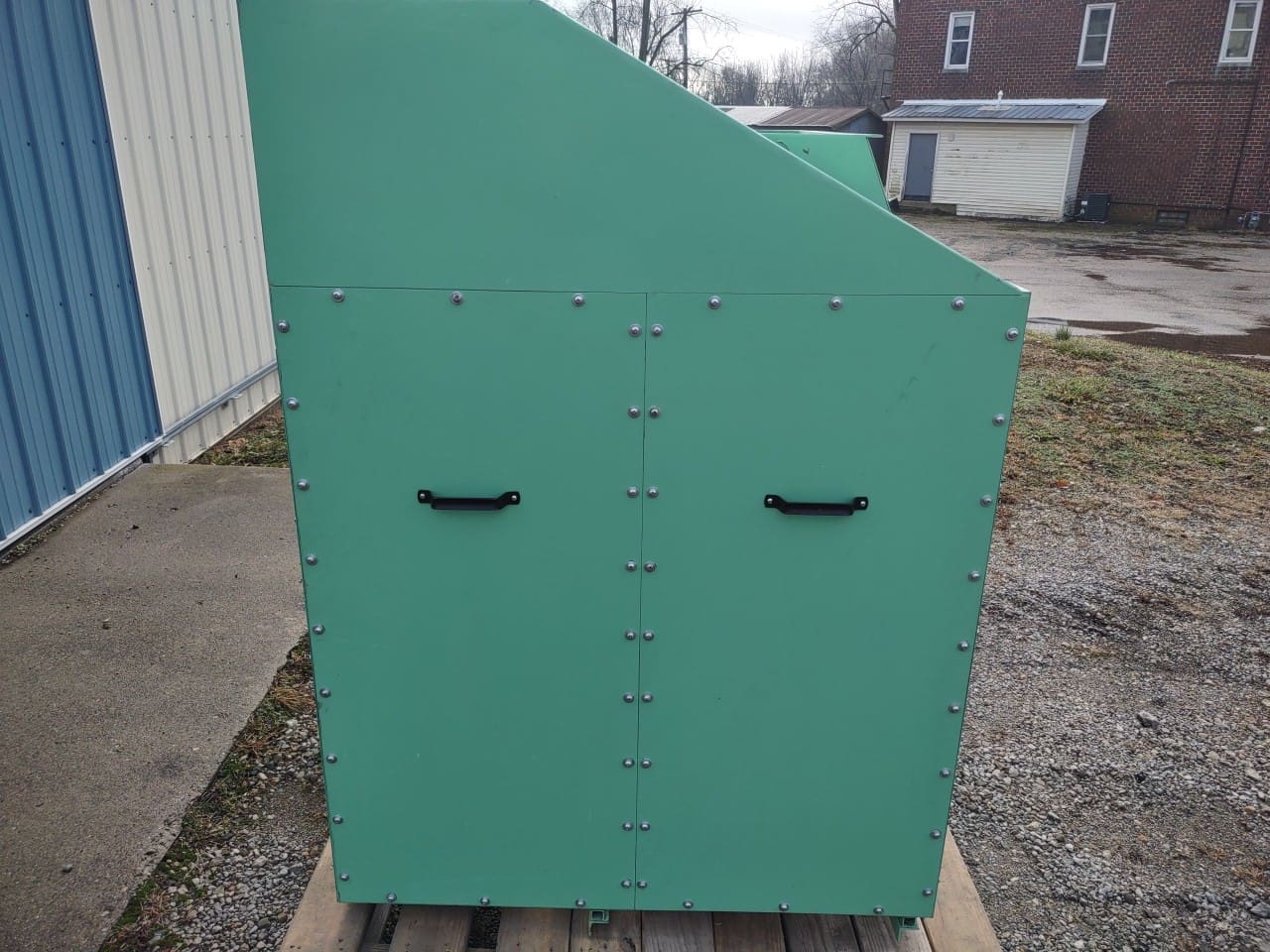 A green cabinet sitting on top of a wooden pallet.