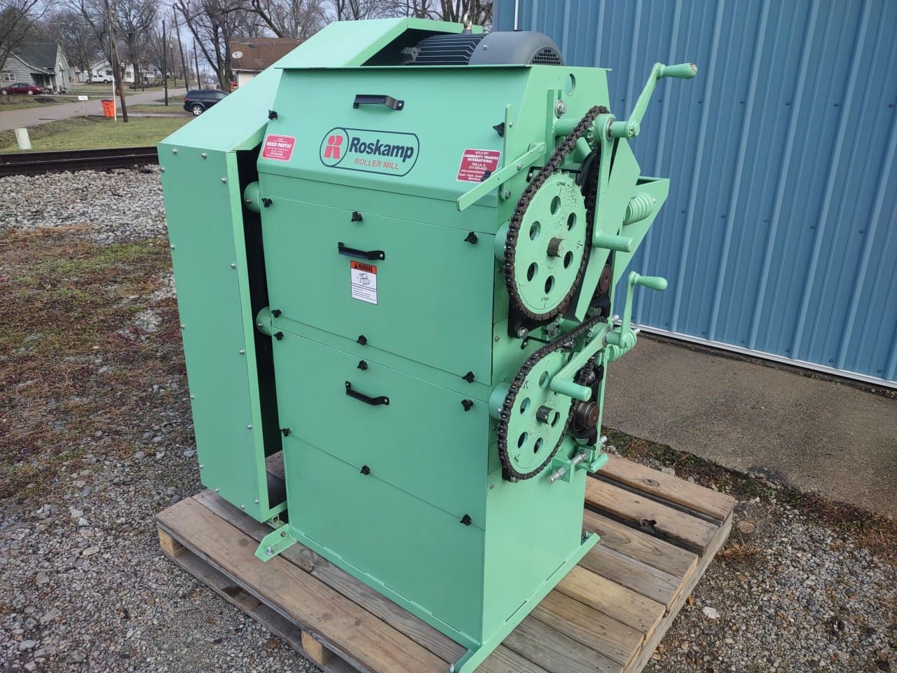 1 (9) A green machine sitting on top of a wooden pallet.