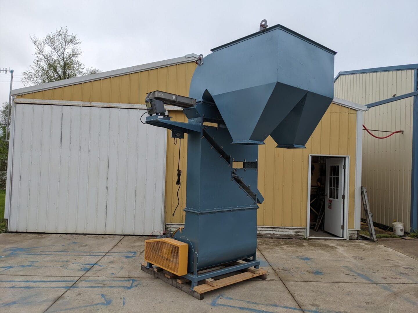 A large blue machine is sitting in the middle of a building.