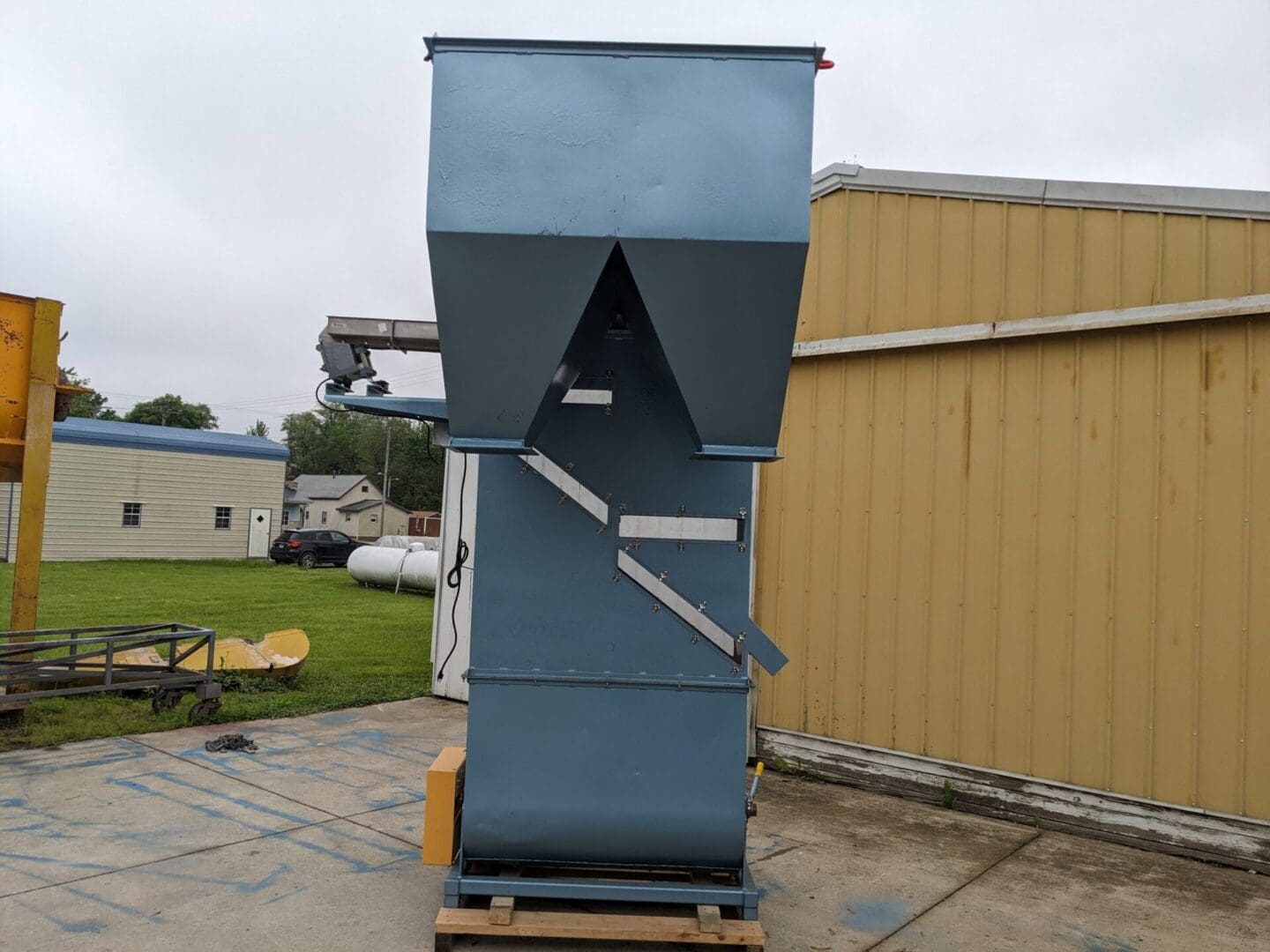 A large blue machine sitting on top of a cement ground.