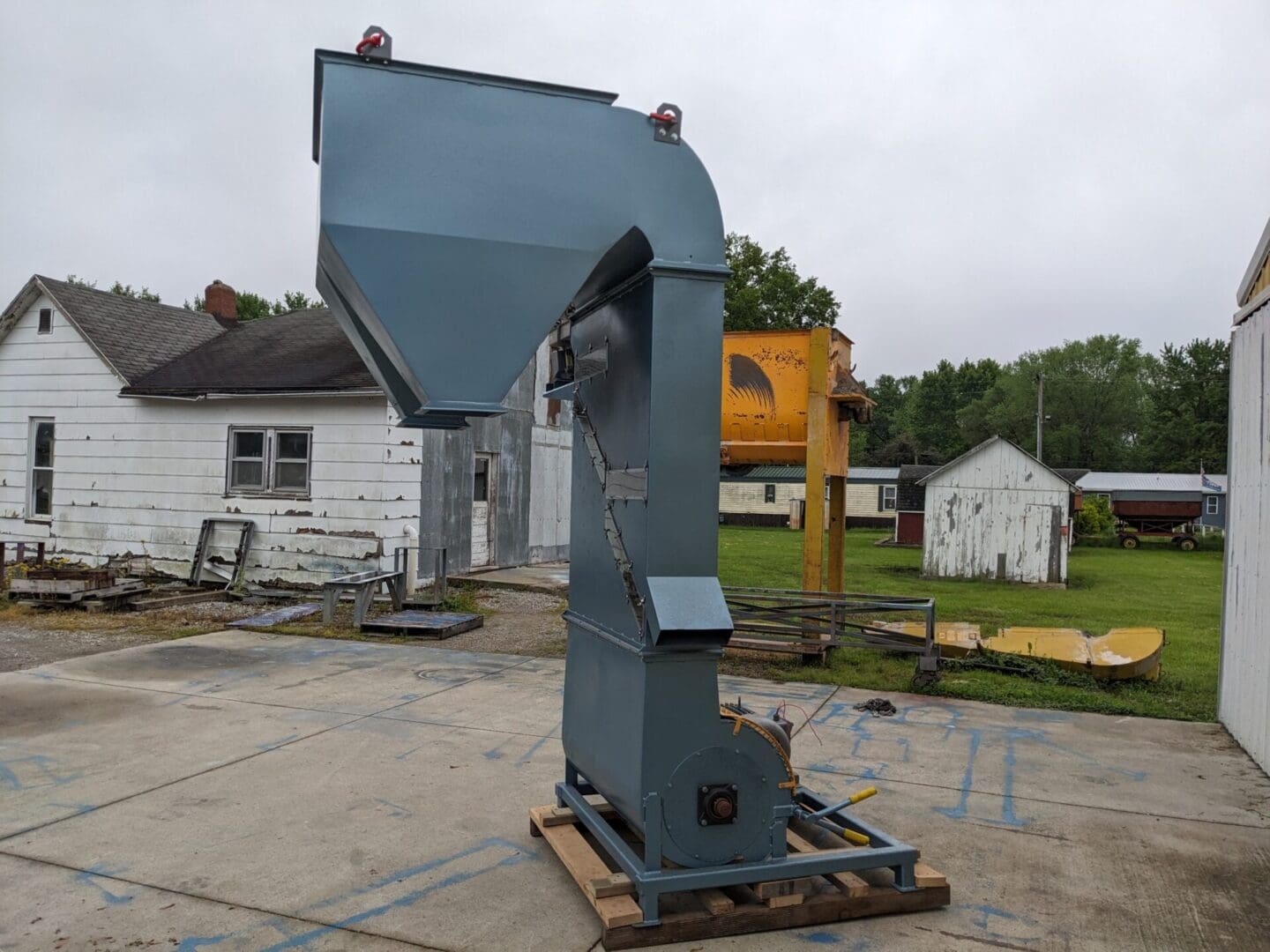 A large blue machine sitting on top of concrete.
