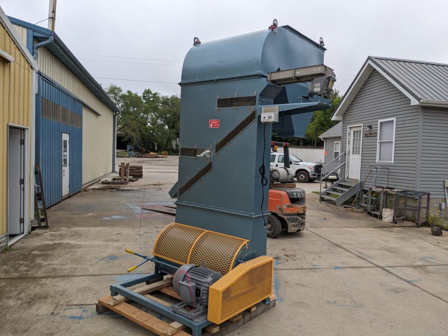 A large blue machine sitting in the middle of a parking lot.