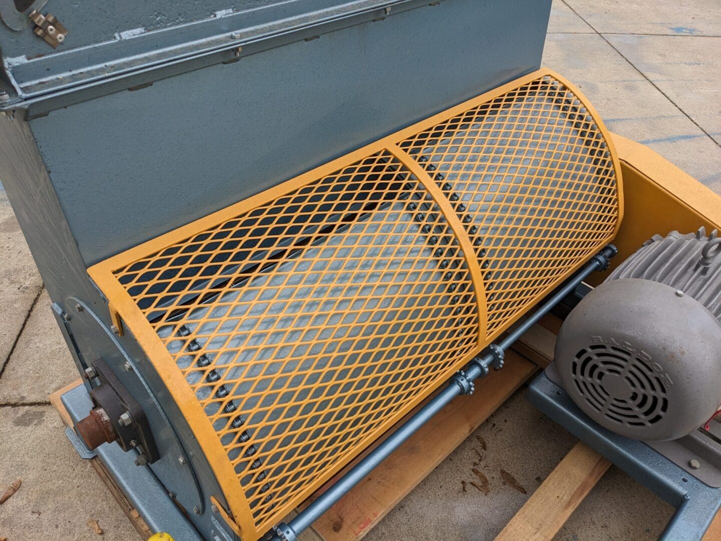 A yellow metal bench sitting on top of a cement floor.