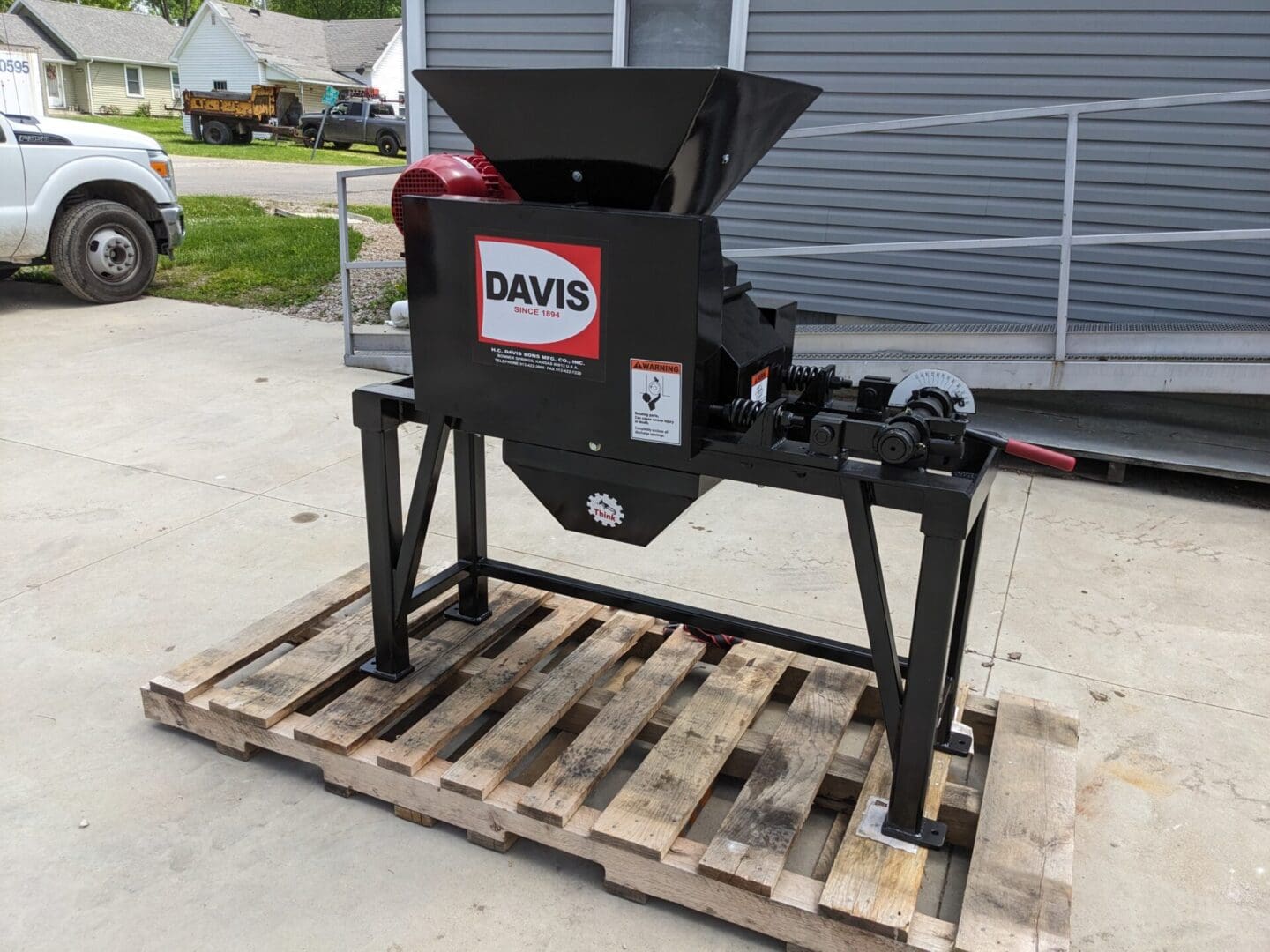 A black machine sitting on top of a wooden pallet.