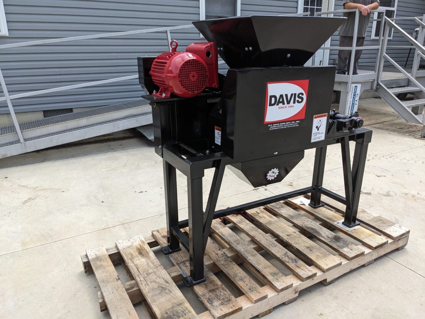 A red and black machine on top of a wooden stand.