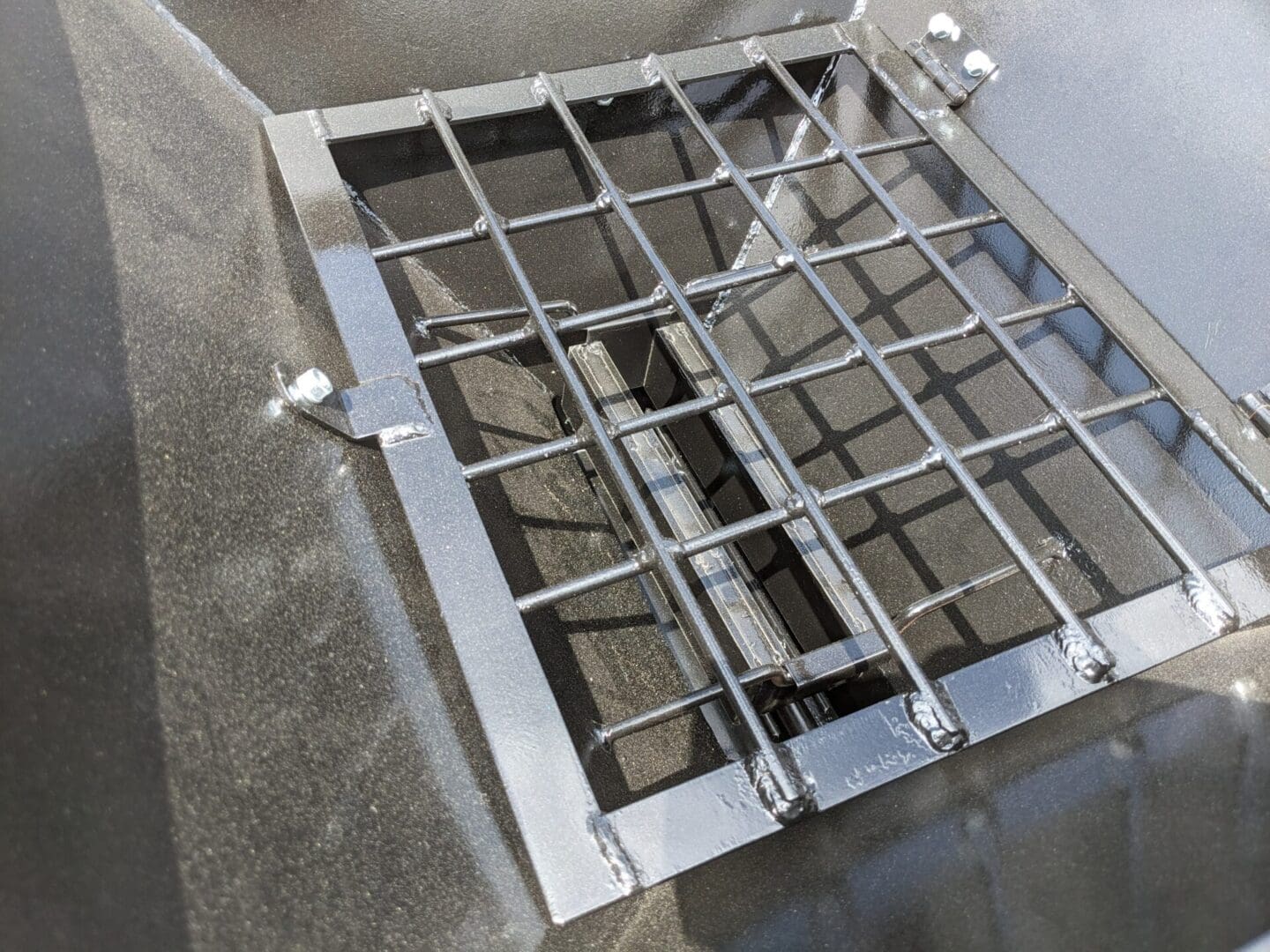 A metal grill with wire mesh on top of it.