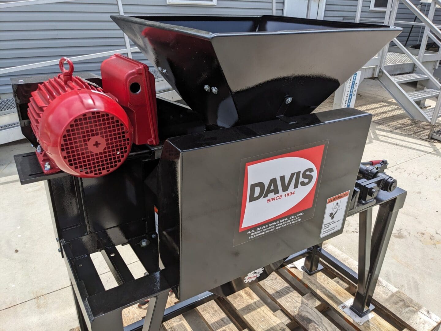 A red and black machine on top of a wooden table.