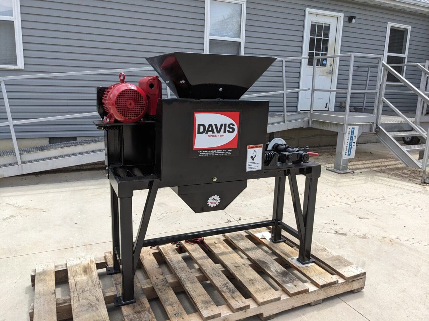 A black machine sitting on top of a wooden pallet.