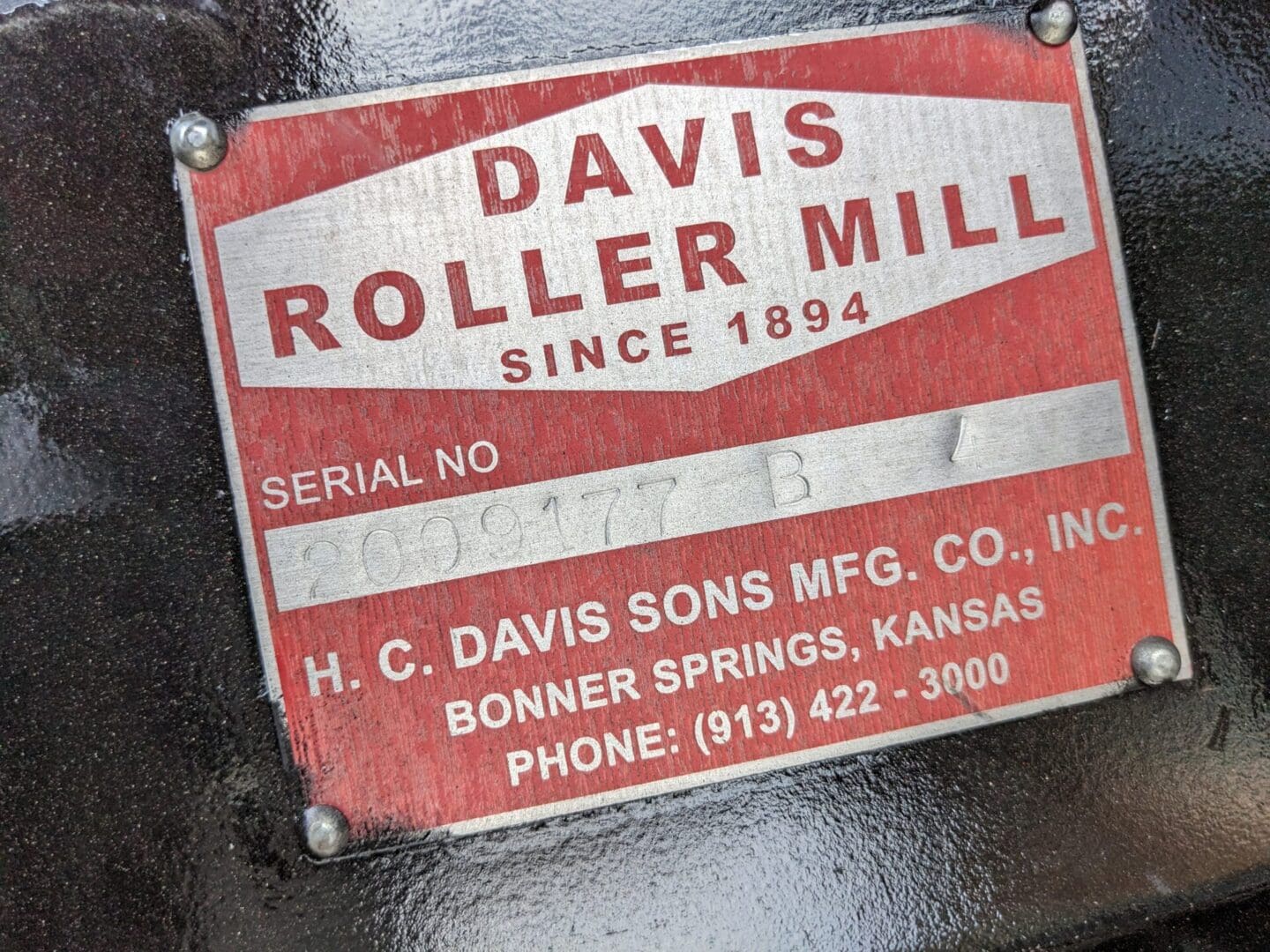 A red and white sign on the side of a machine.