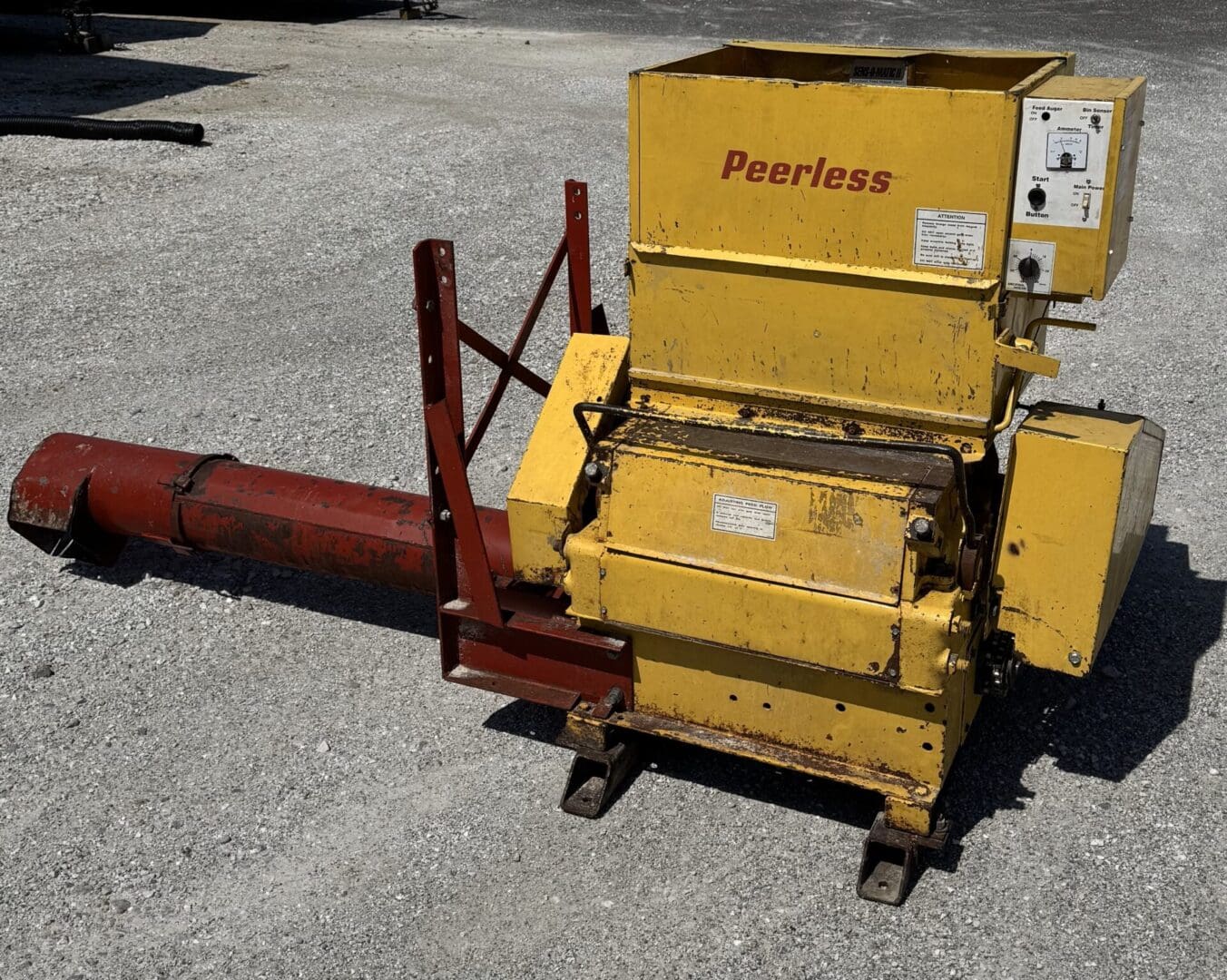 A yellow machine sitting on the ground next to a red pole.
