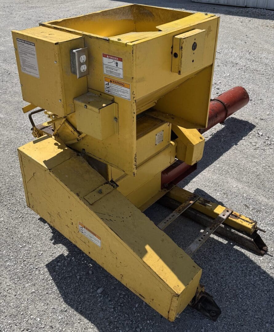 A yellow machine is sitting on the ground.