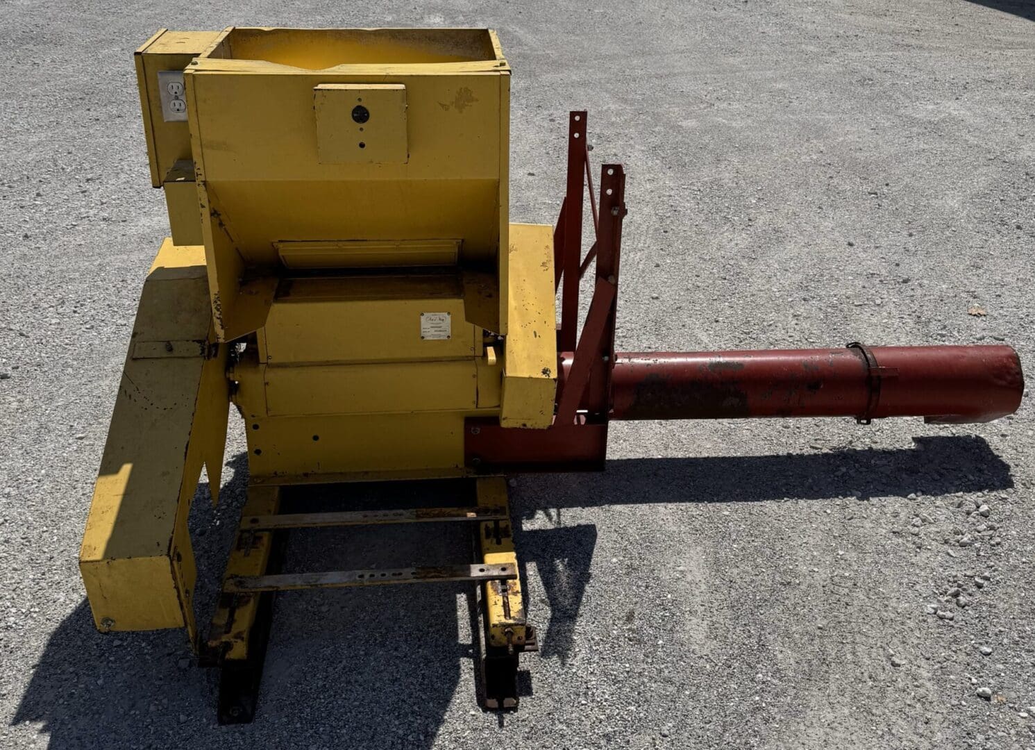 A yellow machine sitting on top of the ground.