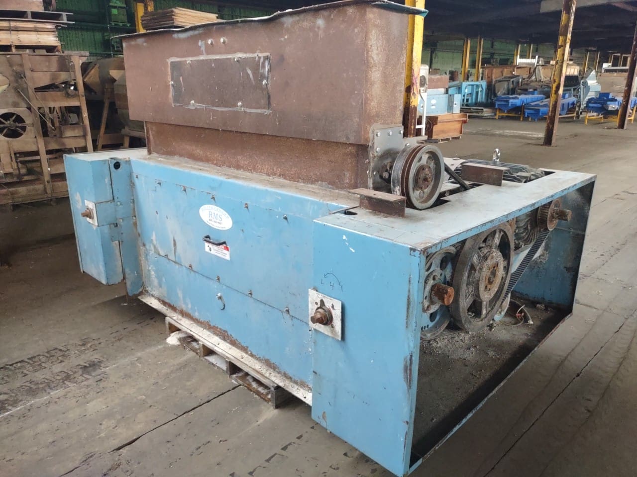 A blue machine with two large metal parts on top of it.