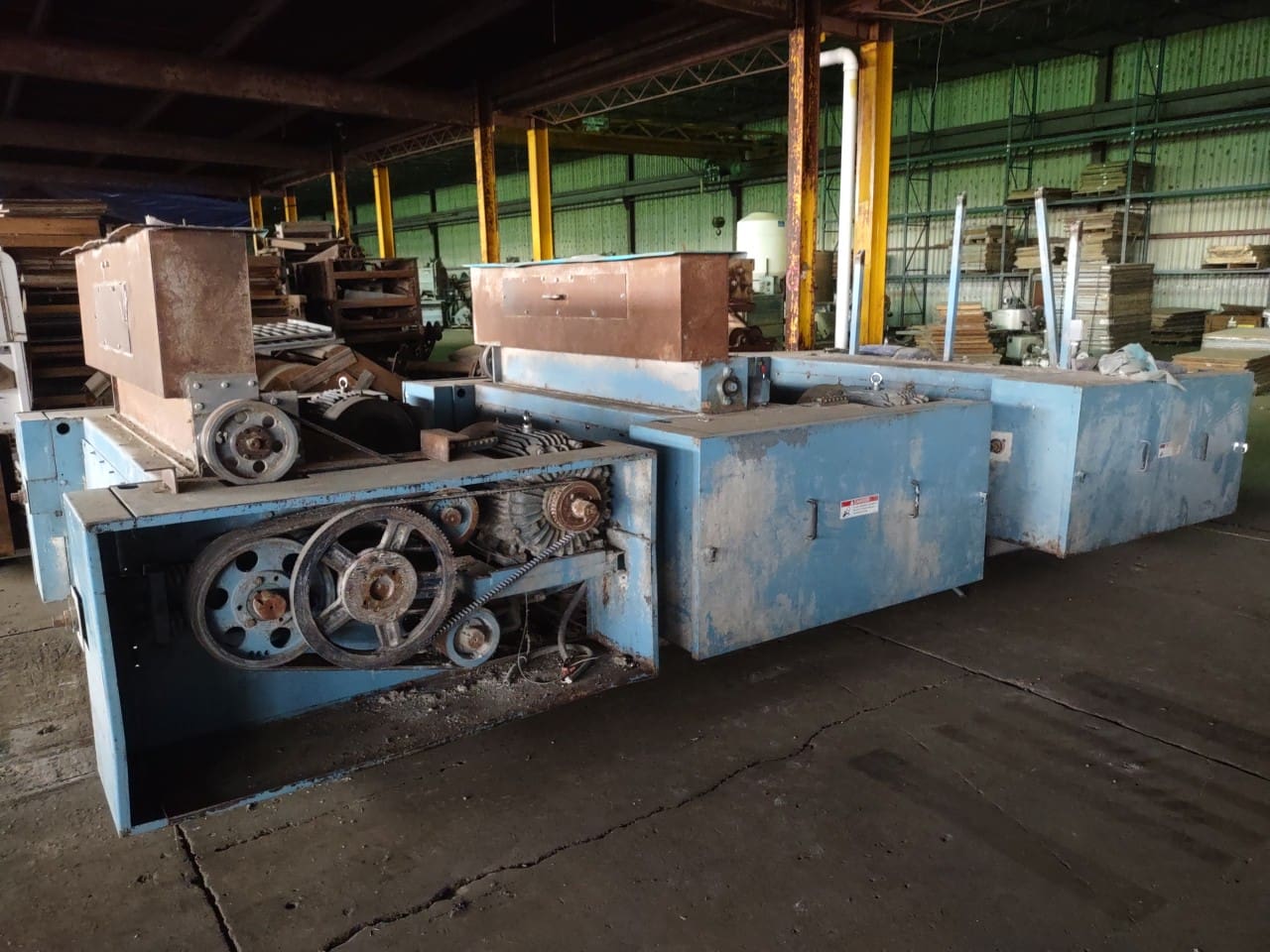 A large machine in an old warehouse with many parts.