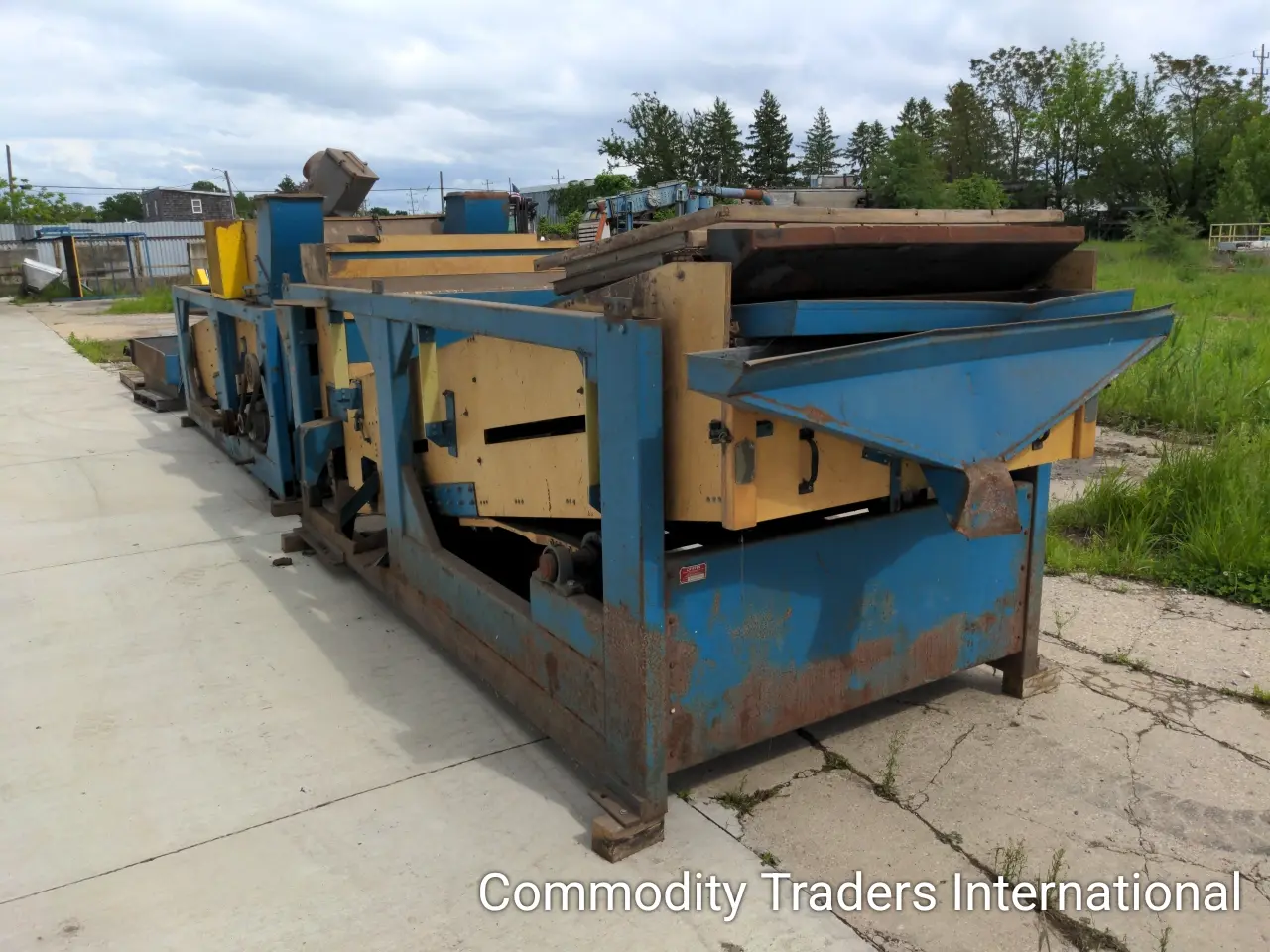 A blue and yellow machine is on the sidewalk.