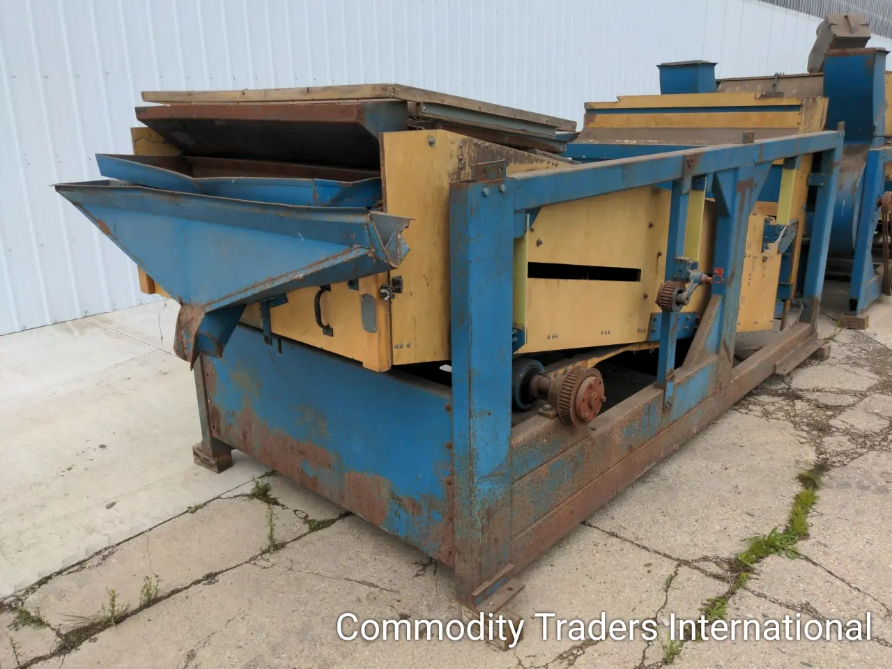 A blue and yellow machine is sitting on the ground.
