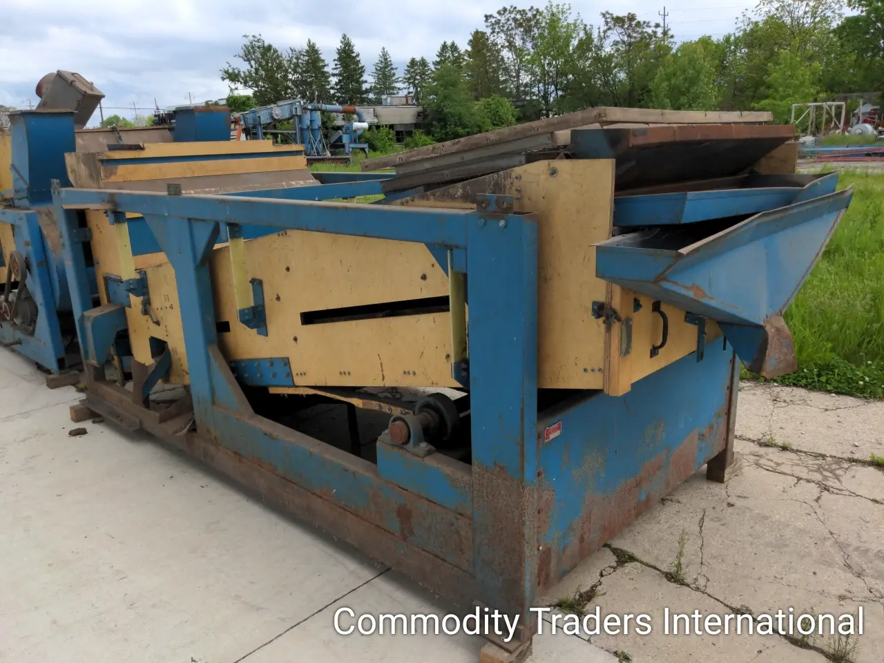 A blue and yellow machine is sitting on the ground.