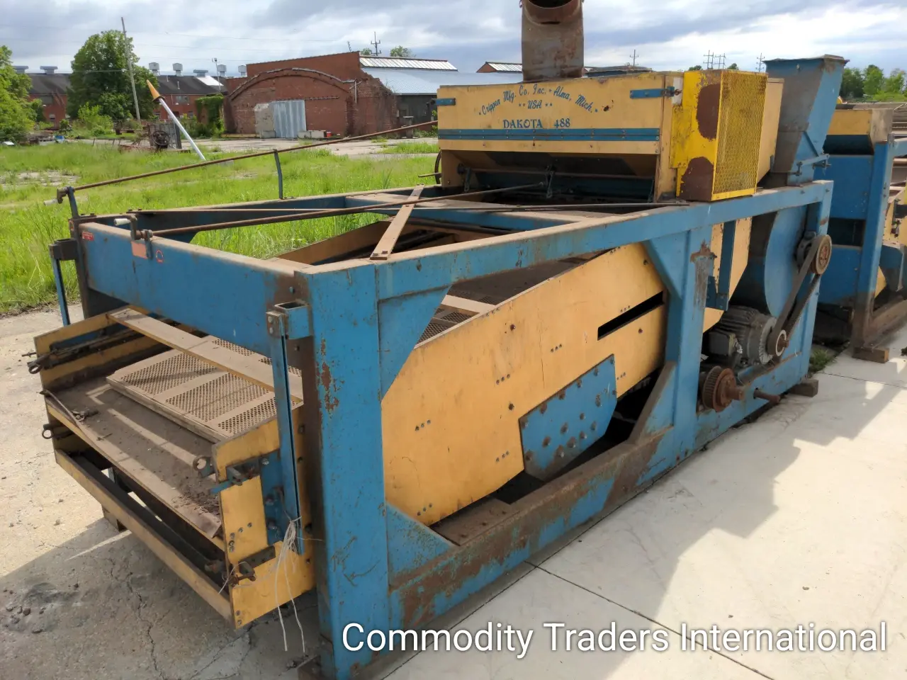 A blue and yellow machine is sitting on the ground.