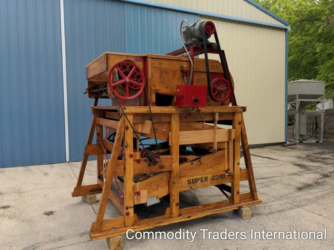A large wooden machine sitting on top of a cement floor.
