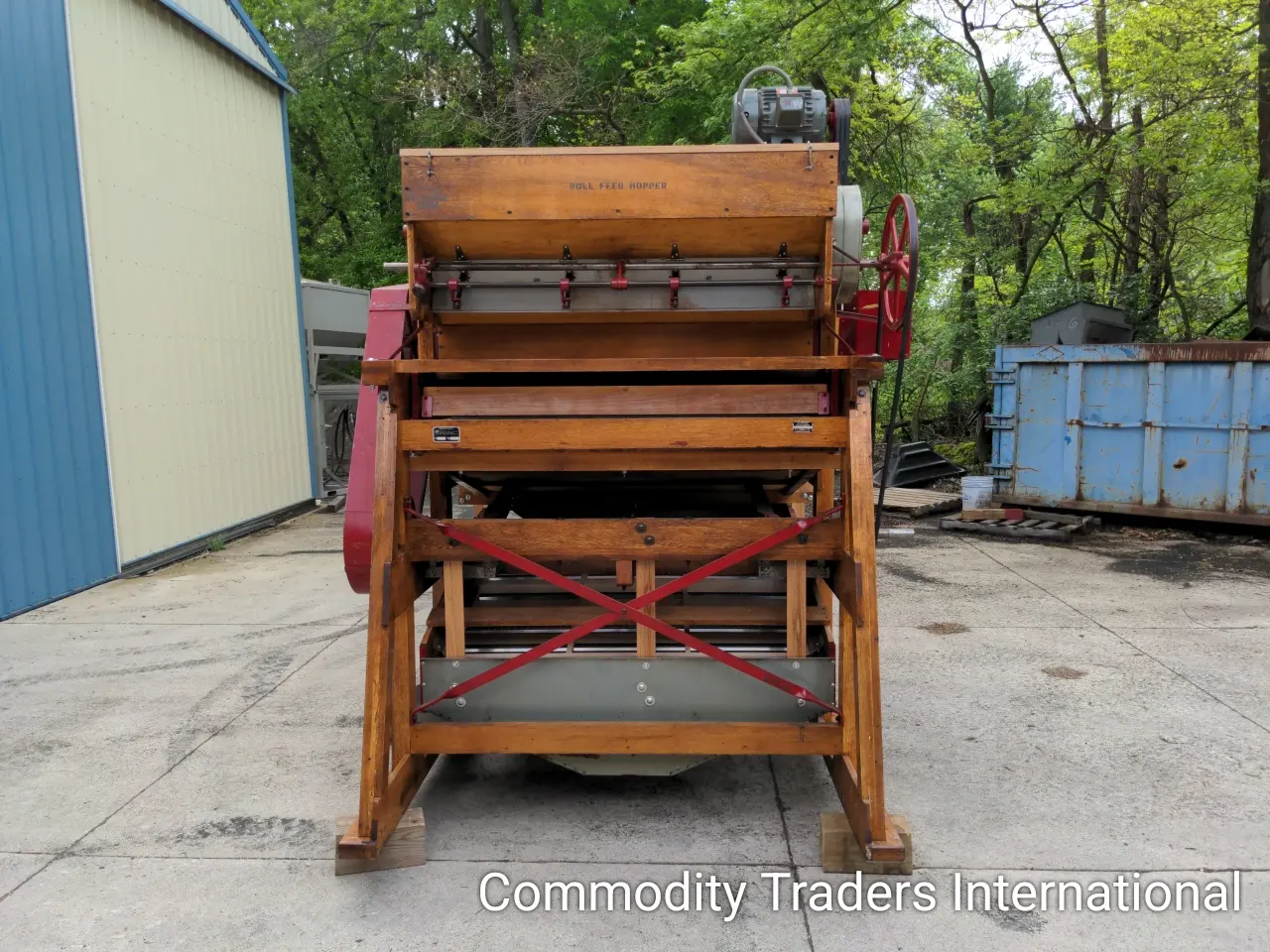 A wooden machine sitting in the middle of a driveway.