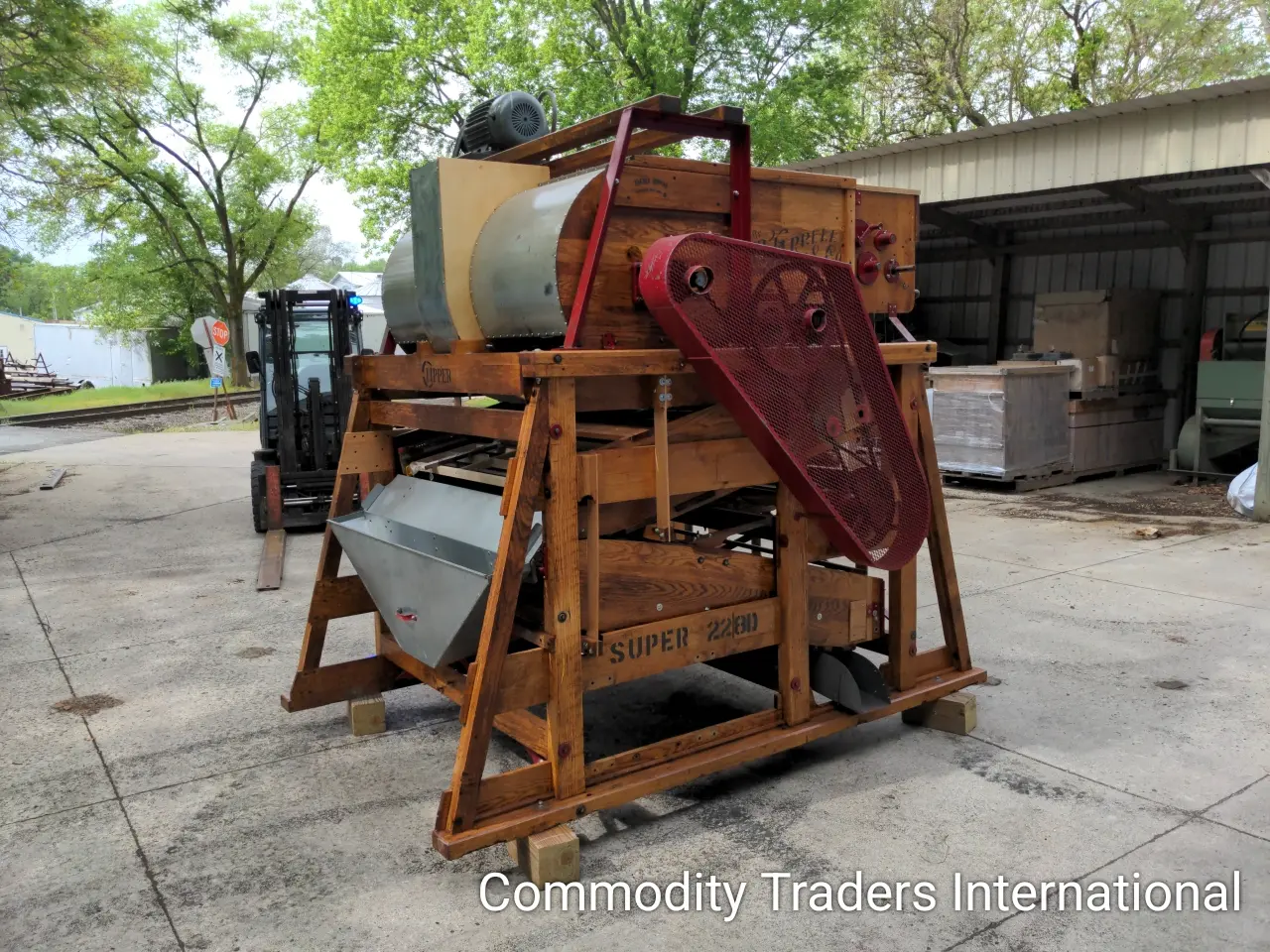 A large wooden machine with a red handle.