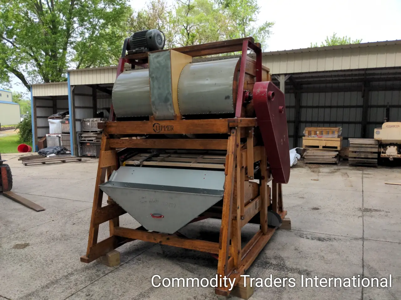 A large wooden machine with two metal buckets.