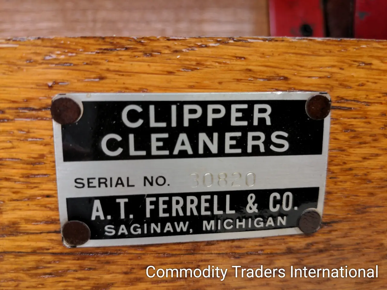 A sign on the side of a wooden table.