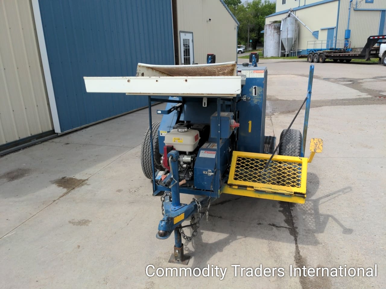 A blue and yellow trailer with a white metal ramp.