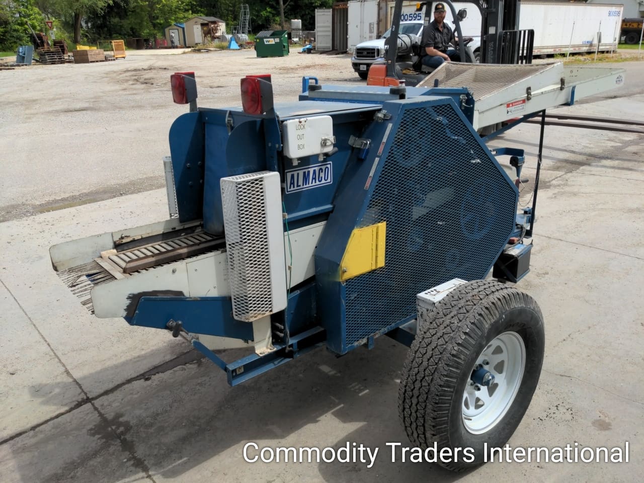A blue trailer with a large metal device on it.